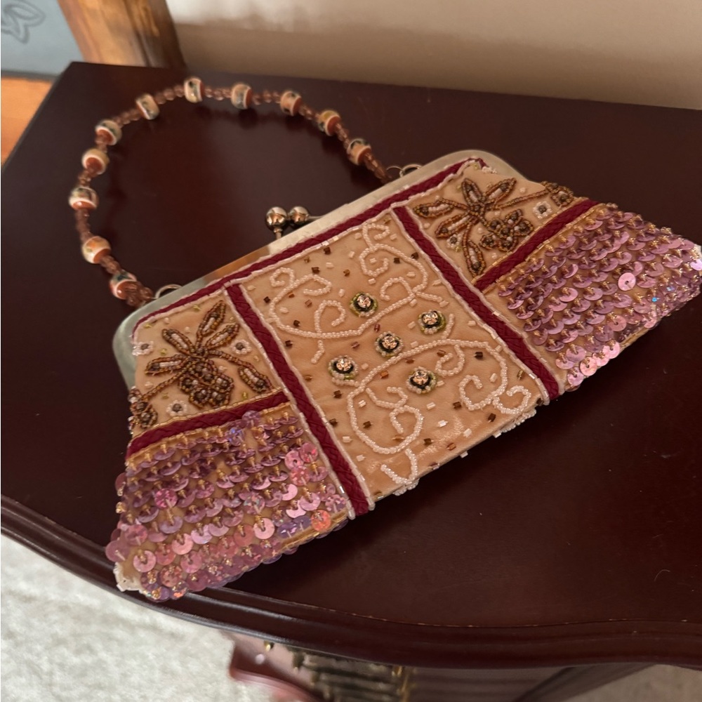 Vintage looking purse with beaded handle. Top snap closure. Like new.